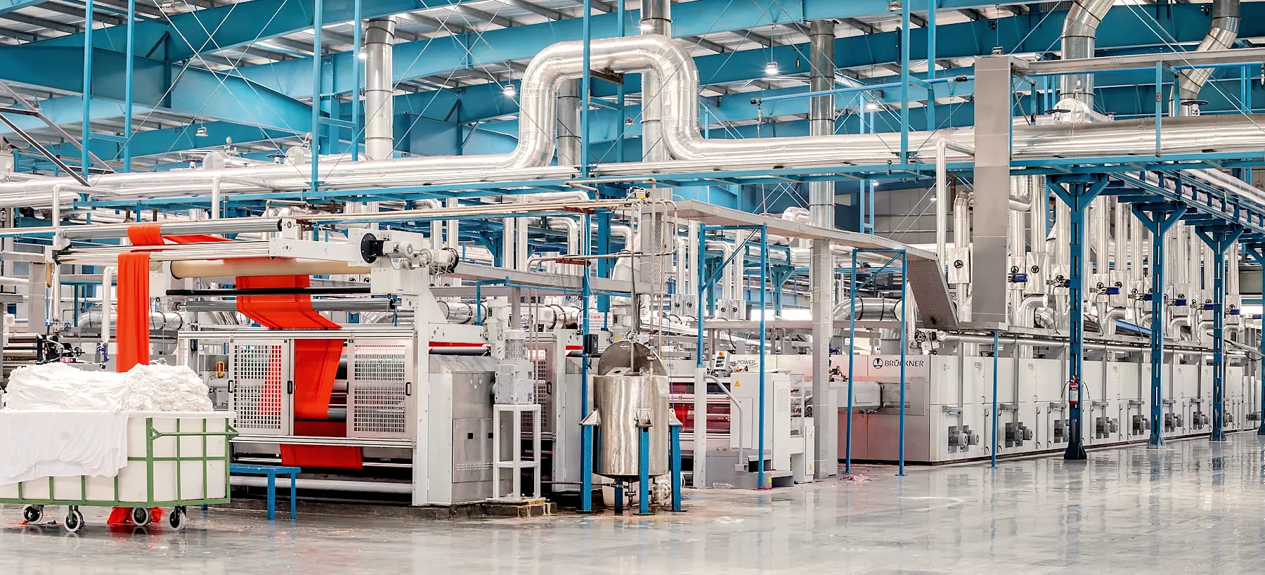 A wide view down a bright production hall with white processing machines