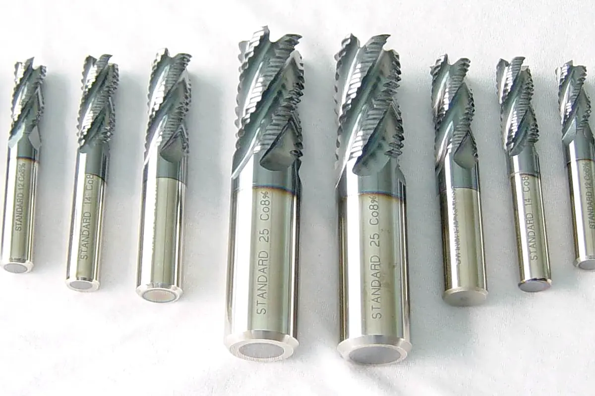 A row of PVD coated roughing end mills standing on a light background